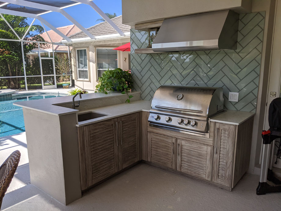 after shot of "Huot Outdoor Kitchen" with a new light green rectangular tile backsplash. Wooden counters and stone countertops